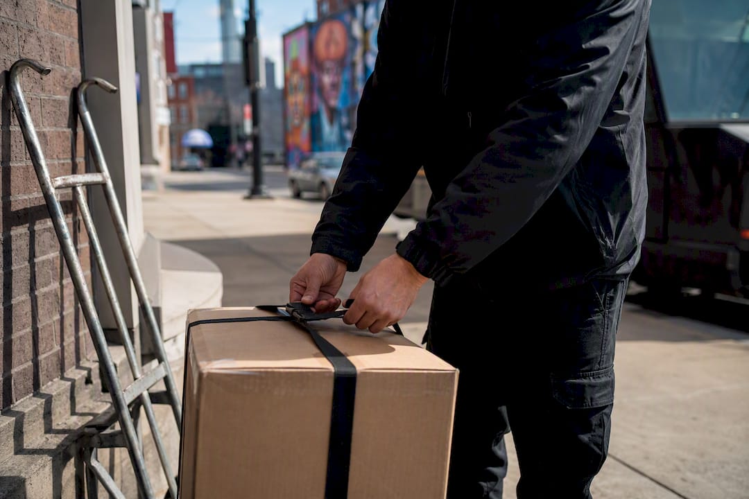 Courier securing package for delivery