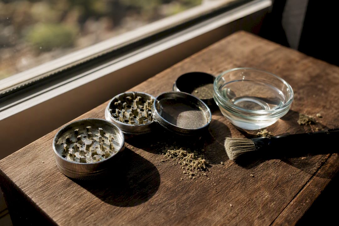 Partially disassembled herb grinder with cleaning tools